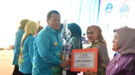 Ketua TP-PKK Lampung Timur, Yus Bariah Dawam Rahardjo saat menerima piala dari Gubernur Arinal Djunaidi. (foto: ist) 