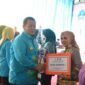 Ketua TP-PKK Lampung Timur, Yus Bariah Dawam Rahardjo saat menerima piala dari Gubernur Arinal Djunaidi. (foto: ist) 