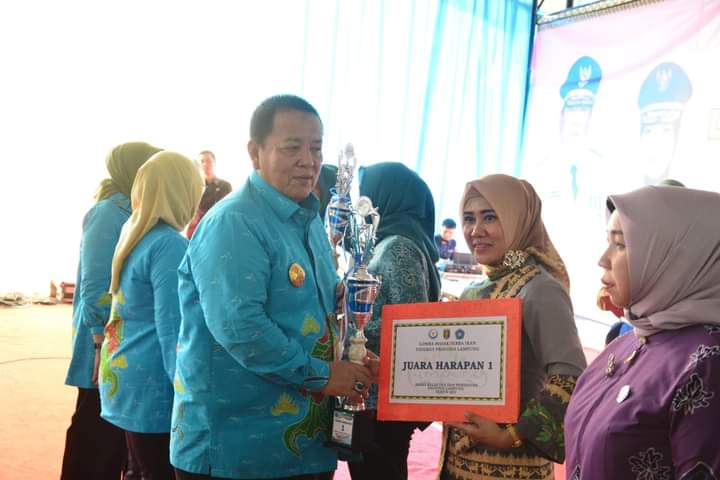Ketua TP-PKK Lampung Timur, Yus Bariah Dawam Rahardjo saat menerima piala dari Gubernur Arinal Djunaidi. (foto: ist) 