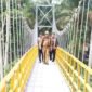 Bupati Lampung Tengah, Musa Ahmad saat melintasi jembatan gantung yang menjadi penghubung antar kampung di Kecamatan Pubian, Senin (12/06/2023). (foto: ist)