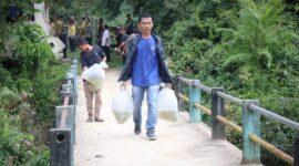 Sejumlah masyarakat saat menebar ribuan benih ikan di sungai Kabupaten Way Kanan, Sabtu (24/06/2023). (foto: ist)