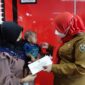 Walikota Bandarlampung, Eva Dwiana saat menyerahkan bantuan untuk biaya pengobatan M Arkana Alfarizki, balita berusia 13 bulan penderita jantung bocor. (foto: ist)