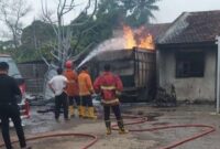 Petugas Damkar berupaya padamkan api gudang BBM di Desa Candimas Kecamatan Natar, Kabupaten Lampung Selatan. (foto: Rio)